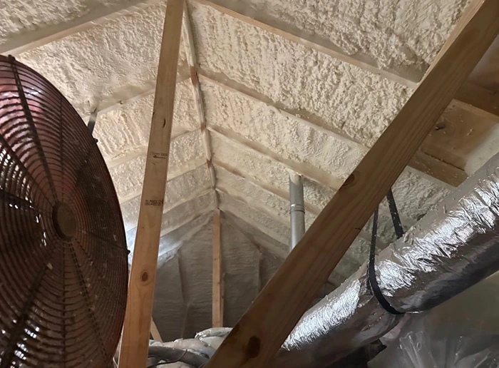 Attic framing and fresh spray foam insulation during reconstruction
